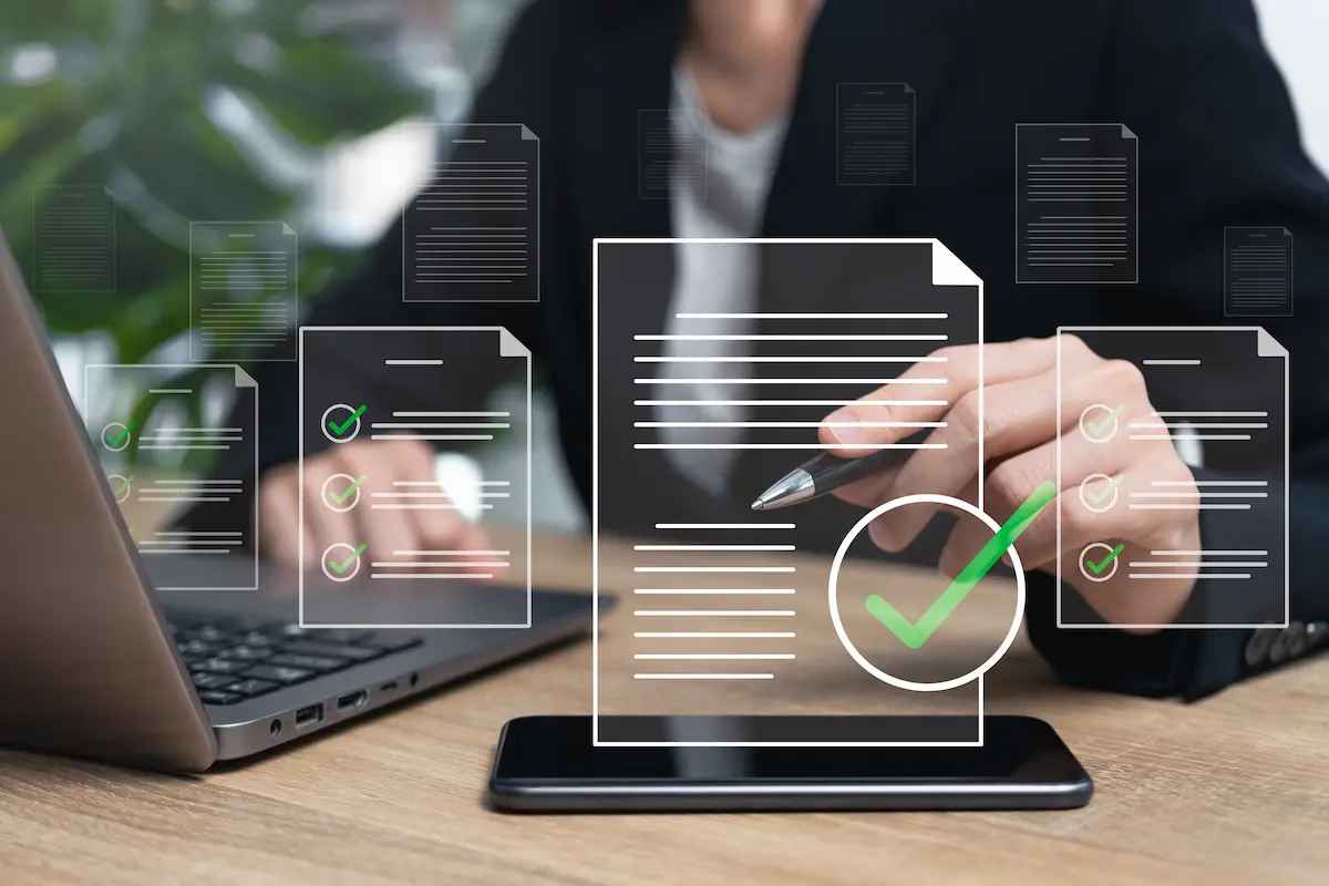 Person using a laptop and stylus with digital checklists and document icons overlaid, representing organized cybersecurity documentation and downloadable policy tools.